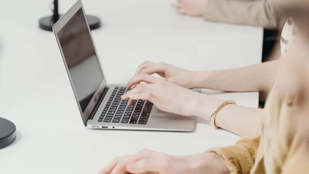Team using connected digital devices around a shared workspace